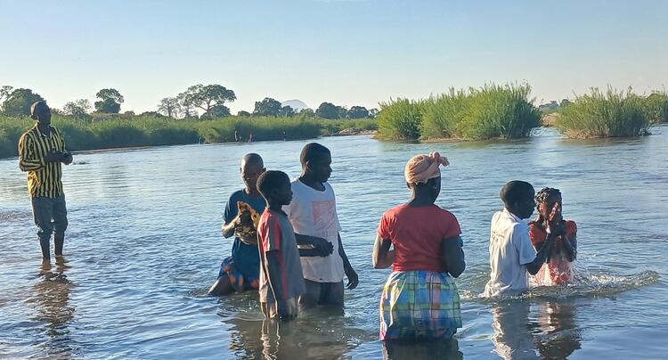 Os recem convertidos tecebendo o baptismo no rio 