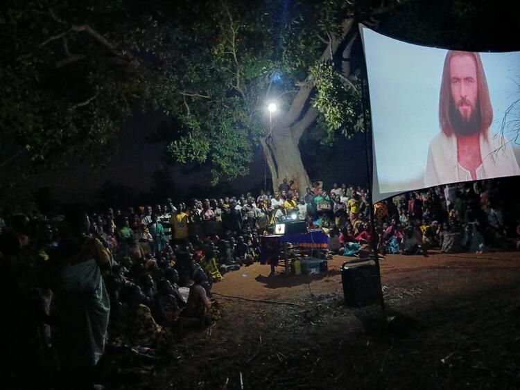 Refugiado assistindo filme de Jesus